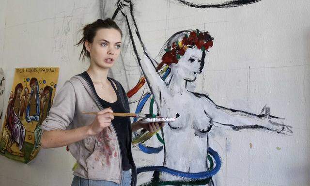 Oksana Shachko, activist of women's rights group Femen, paints a wall of her room in Kiev