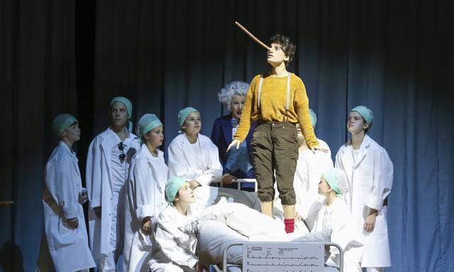 Vorbildlicher Chor, hier in medizinischer Mission: Pinocchio (Juliette Khalil) soll bittere Arznei schlucken.