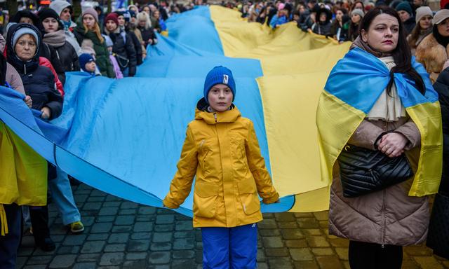 Solidarität mit der überfallenen Ukraine: Eine riesige ukrainische Fahne wird durch Vilnius getragen.