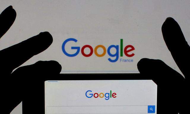 A woman holds her smart phone which displays the Google home page, in this picture illustration