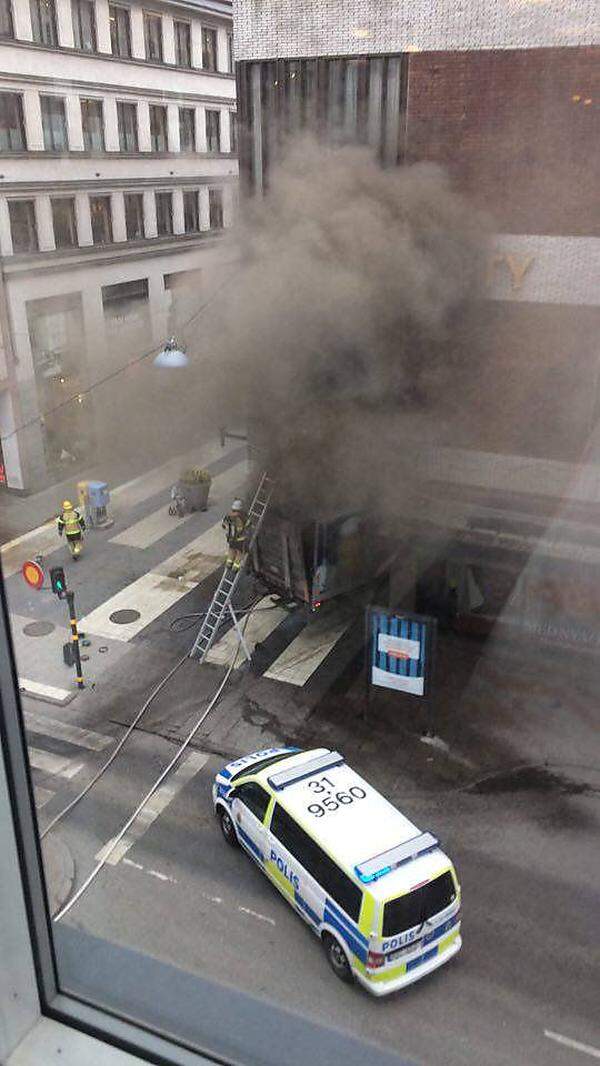Die Fahrt des Lkws endete beim Gebäude des Kaufhauses Åhléns; Rauchschwaden zogen bei der Unfallstelle auf.