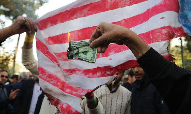 Iranische Demonstranten verbrennen Dollarscheine. Als Weltleitwährung ist der Dollar schon länger angezählt. 