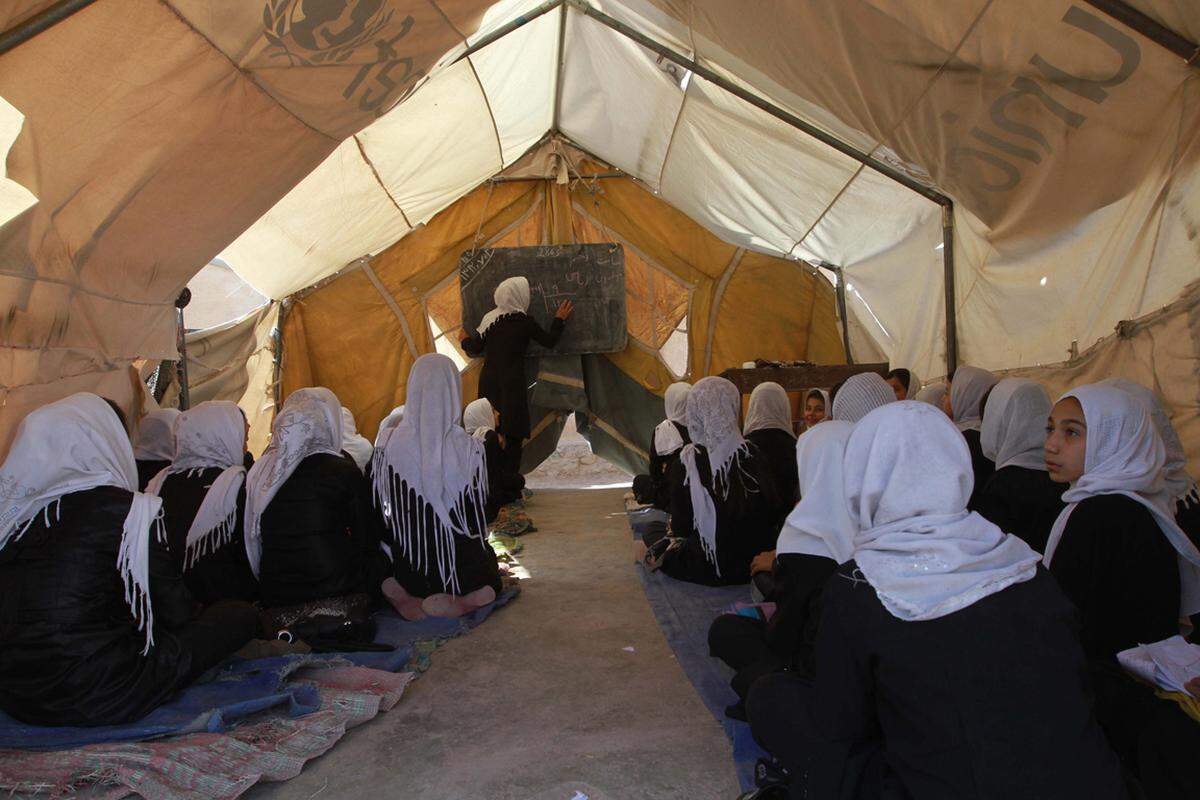 Die meisten afghanischen Frauen und Mädchen können weder lesen noch schreiben. Diese Schülerinnen haben Unterricht in einem provisorischen Camp. An tatsächlichen Schulgebäuden herrscht in Afghanistan Mangel.