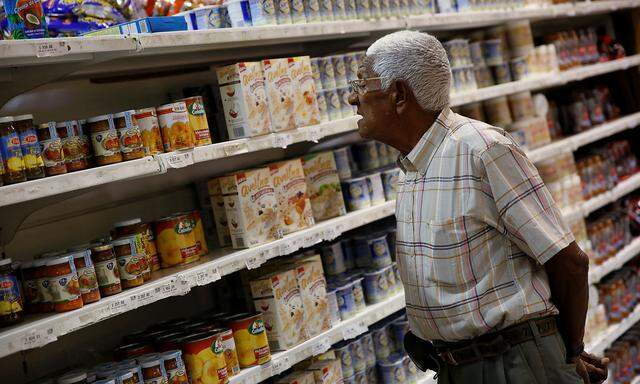 A man looks for groceries and goods at a supermarket in Caracas