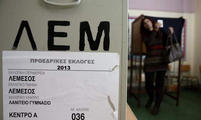 A woman leaves a booth on her way to cast a ballot at a polling station in Limassol
