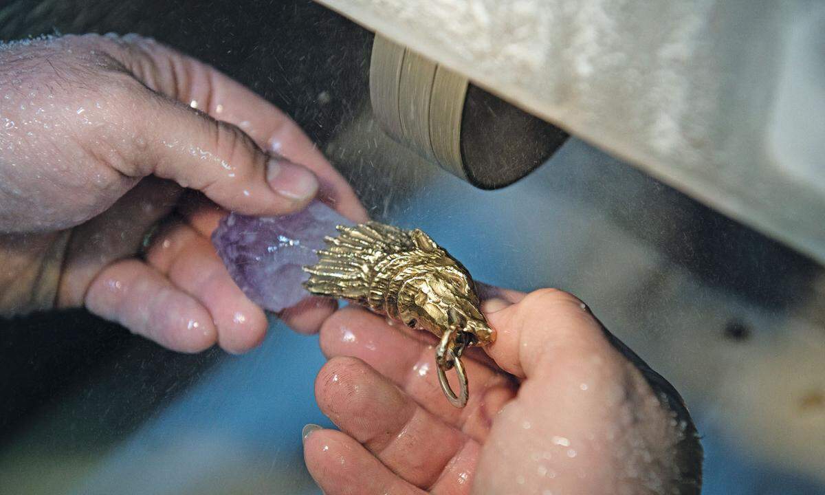 Die zuvor aus Edelmetall gegossenen Tierköpfe werden sorgfältig mit den Steinen verbunden.