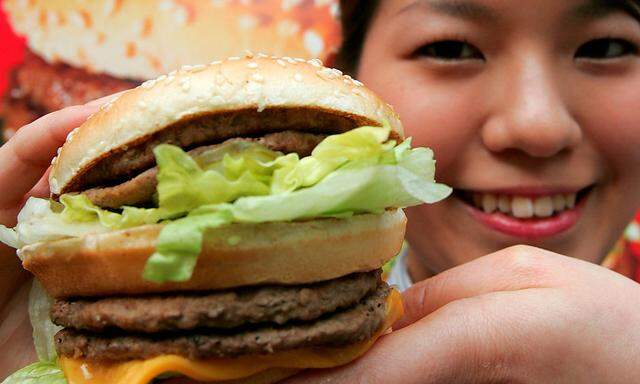 A McDonald's employee displays a Mega Mac burger at a McDonald's outlet in Tokyo