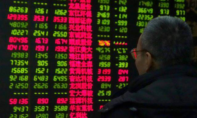 150119 BEIJING Jan 19 2015 An investor looks through stock information at a trading hall