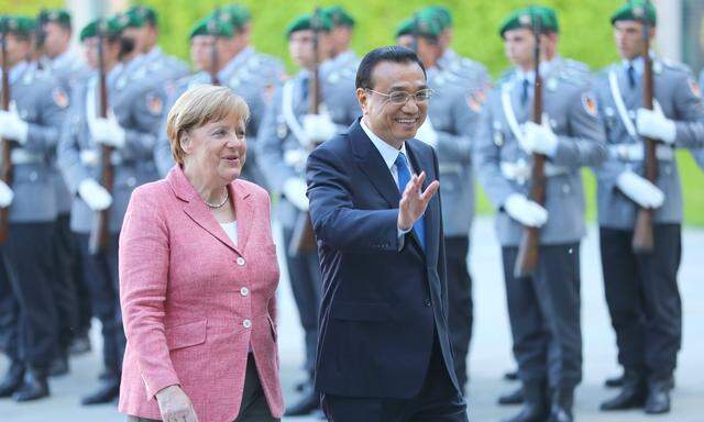 German Chancellor Angela Merkel and Chinese Premier Li Keqiang review the guard of honour during a welcome ceremony at the Chancellery in Berlin