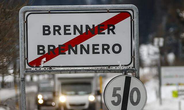 Cars drive along a street with a sign reading ´Brenner-Brennero´ in the Italian village of Brenner on the Italian-Austrian border