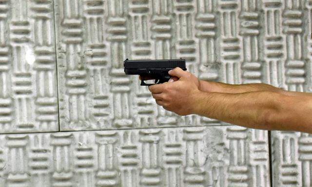 Israeli settler Aviel Barron practices firing his newly bought glock pistol at a shooting range in a
