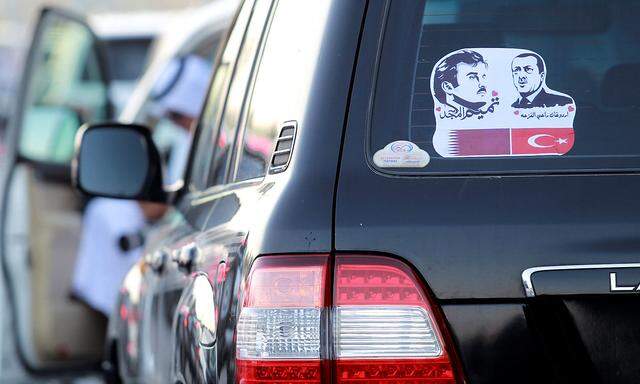 Die Bilder des Emirs von Katar und des Präsidenten der Türkei auf einem Auto in Doha.