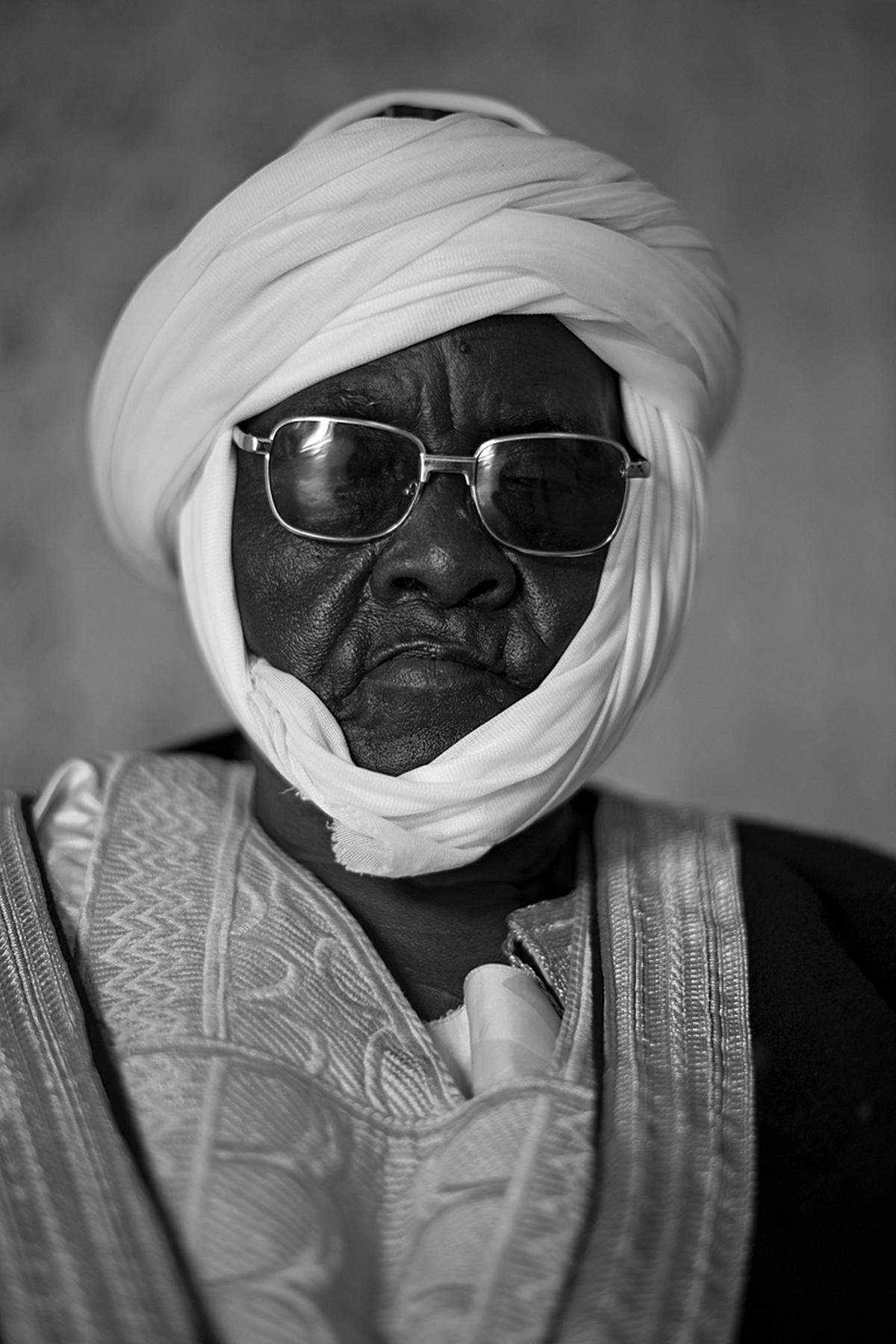 Bissagou Mamadou, Lamido of Mokong, Kamerun (c) Alfred Weidinger Weidinger: "Der Lamido von Mokong posiert mit Sonnenbrille und zwei Notablen. Im Hintergrund fand sich während der Aufnahme seine gesamte Familie ein."
