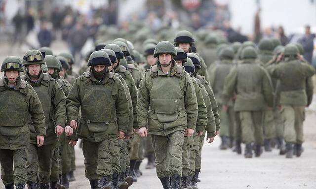 Uniformed men march outside a Ukrainian military base in the village of Perevalnoye