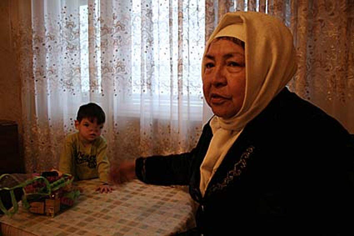 Der kleine Timur (links hinten) kam mit einem Geburtsfehler auf die Welt; dennoch erhält er keine Invalidenrente. Die NGO-Mitarbeiterin Gulzyhan Zhumataeva (rechts) unterstützt die Familie.