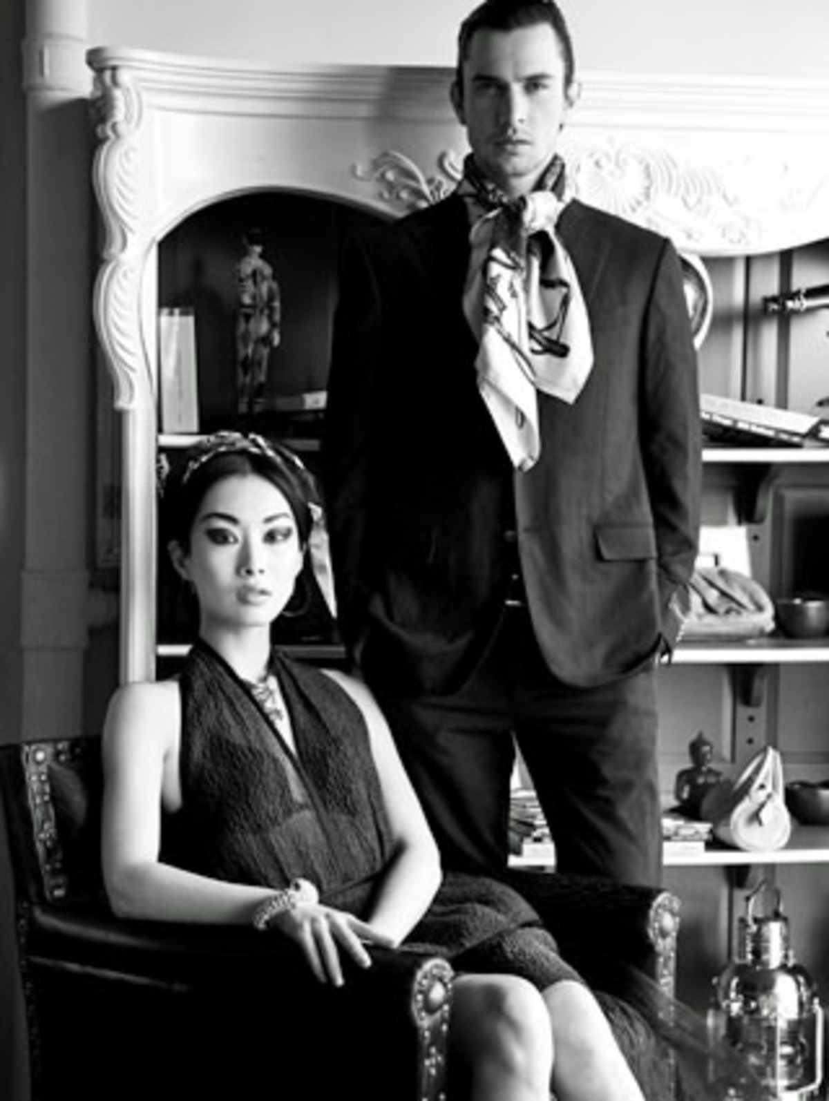 Kleid von Prada, Kopftuch von Hermès, Halskette von Jean Paul Gaultier für Swarovski über Agentur Mostbeck, Armband von Swarovski, Anzug von Zegna, Halstuch von Hermès. Auf dem Regal: Tasche von Miu Miu bei Chegini. Alle Preise auf Anfrage.