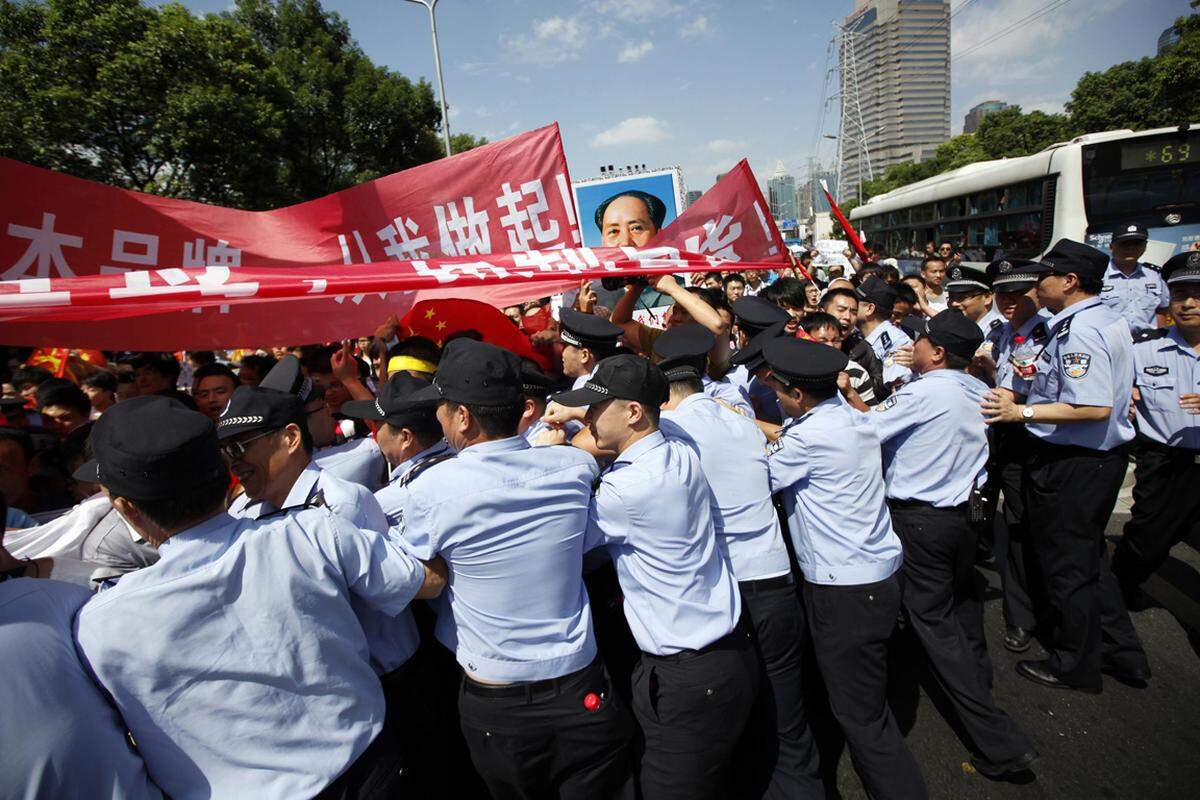 In Shangai versuchen wütende Chinesen, die Sperre vor dem japanischen Konsulat zu durchbrechen.