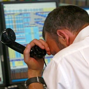 A trader from BGC, a global brokerage company in London's Canary Wharf financial centre reacts during trading