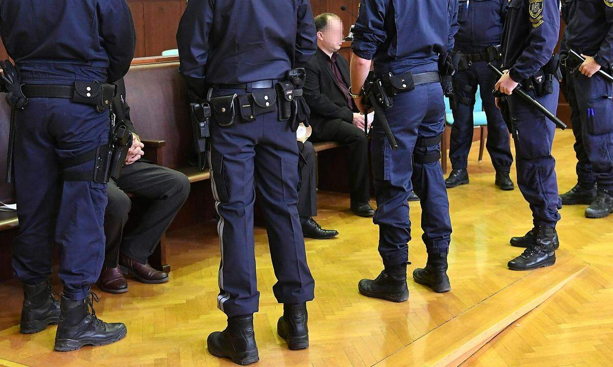 Die Angeklagten mit Polizisten im Gerichtssaal.