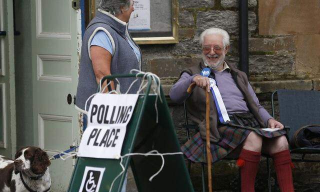 A supporter of the 'Yes' campaign sits outside a polling station during the referendum on Scottish independence in Pitlochry