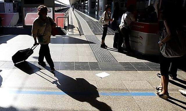 Passengers walks with their luggage at Termini station in downtown Rome