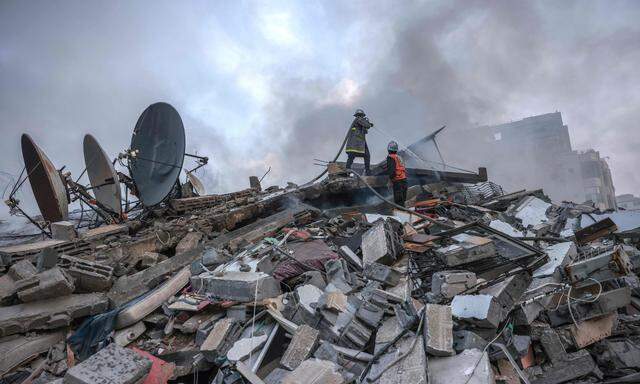 Palästinensische Feuerwehreute bei Löscharbeiten an einem Haus in Gaza nach einem israelischen Vergeltungsschlag. 