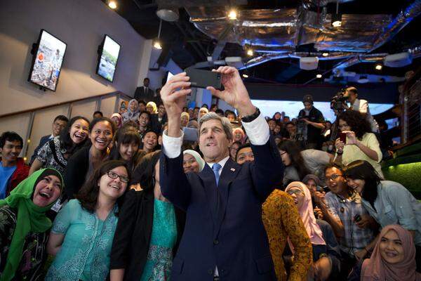 Zuerst das "Selfie" dann die Rede: US-Außenminister John Kerry wirft sich für ein Foto mit Studenten in Jakarta in Schale. Danach spricht er über den Klimawandel.