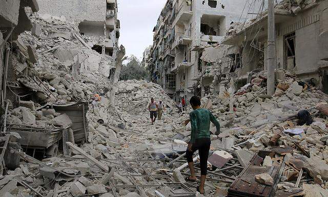 People inspect a damaged site after airstrikes on the rebel held Tariq al-Bab neighbourhood of Aleppo
