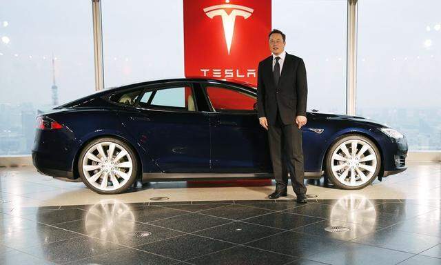 Tesla Motors Inc Chief Executive Musk poses with a Tesla Model S electric car in Tokyo