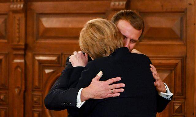Merkel und Macron umarmen sich.