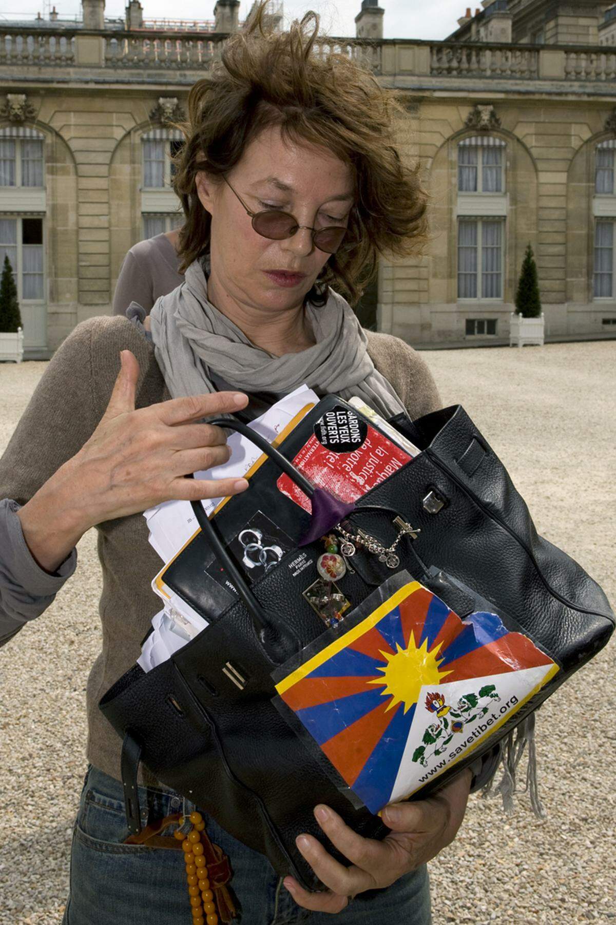 In Paris präsentierte sich Jane Birkin jetzt mit ihrer Birkin-Bag, die sie ganz schön individualisierte. Klebestreifen, Sticker und Perlenketten finden sich auf dem schwarzen Klassiker.