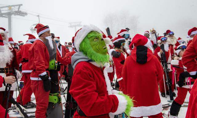 Disruption im Weihnachtstrubel: ein grüner Grinch in einer Legion von Santa-Claus-Akteuren bei einem Charity-Event in Newry, Maine.