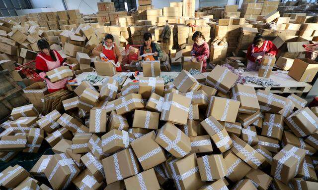 Chinesische Postmitarbeiter sortieren die Paketberge, die Alibaba am selbst erfundenen Singles’ Day in die Welt schickt.