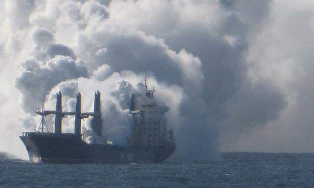 A handout picture obtained from the Havariekommando website shows cargo vessel Purple Beach loaded with fertilizers engulfed in smoke, west of Helgoland