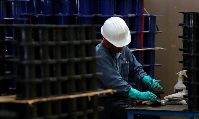 Worker inspects a plastic roll at TIM stainless steel wire factory in Huamantla