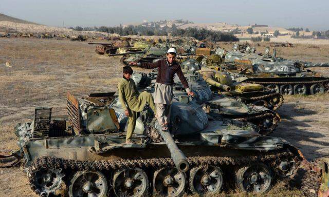 Afghanische Kinder spielen auf abgewrackten sowjetischen Panzern in einem Randbezirk der Stadt Jalalabad.