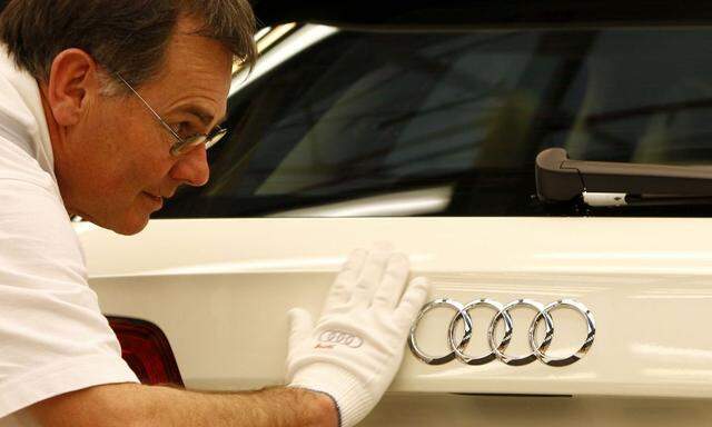 Worker cleans Audi A3 in final check area at production line of German car manufacturer's plant in Ingolstadt