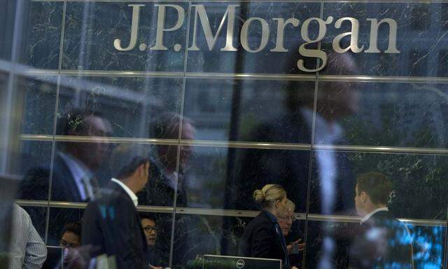 Workers are reflected in the windows offices of JP Morgan