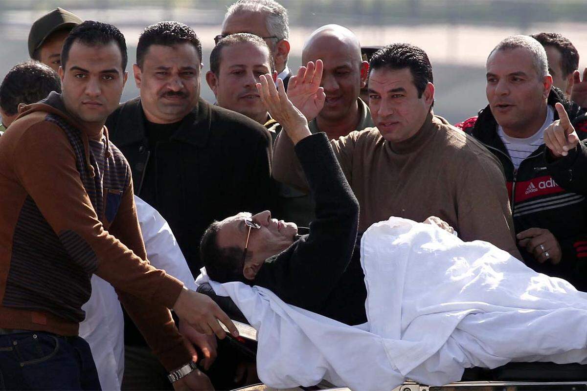 Der ägyptische Exdiktator Hosni Mubarak liegt winkend auf der Bahre, das Verfahren gegen ihn wurde eingestellt. Mubarak war angeklagt, für die Tötung von hunderten Demonstranten während des Aufstands im Frühjahr 2011 mitverantwortlich zu sein.