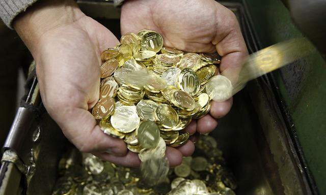 An employee of the city mint holds freshly produced 10-rouble coins in St. Petersburg