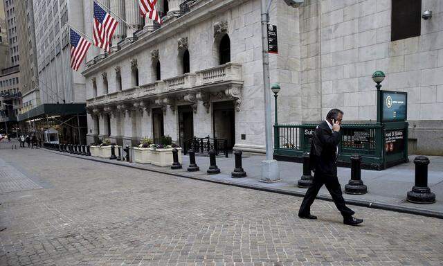 Trader walks outside New York Stock Exchange (NYSE) before opening bell of trading session in New York