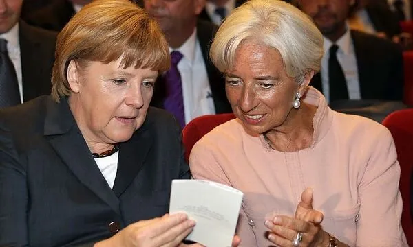 German Chancellor Merkel and the Director of the IMF Lagarde look at the programme as they attend the 70th birthday reception for German Finance Minister Schaeuble in Berlin