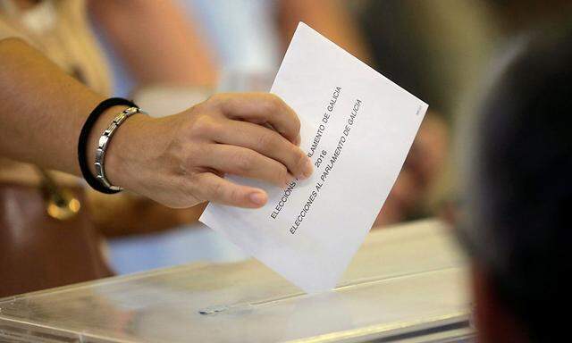 A woman casts her vote during the regional elections at a polling station in Vigo