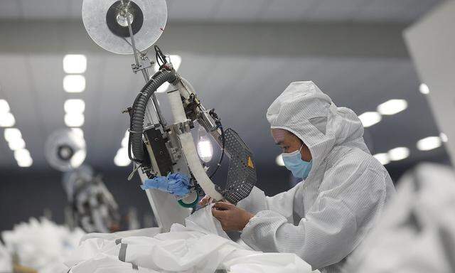 Employee works on a production line manufacturing protective suits at a medical supply factory in Xinzhou district of Wuhan