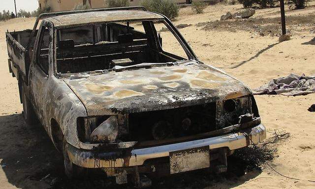 The wreckage of a burnt car is seen after assaults on militant targets by the Egyptian Army, in a village on the outskirts of Sheikh Zuweid