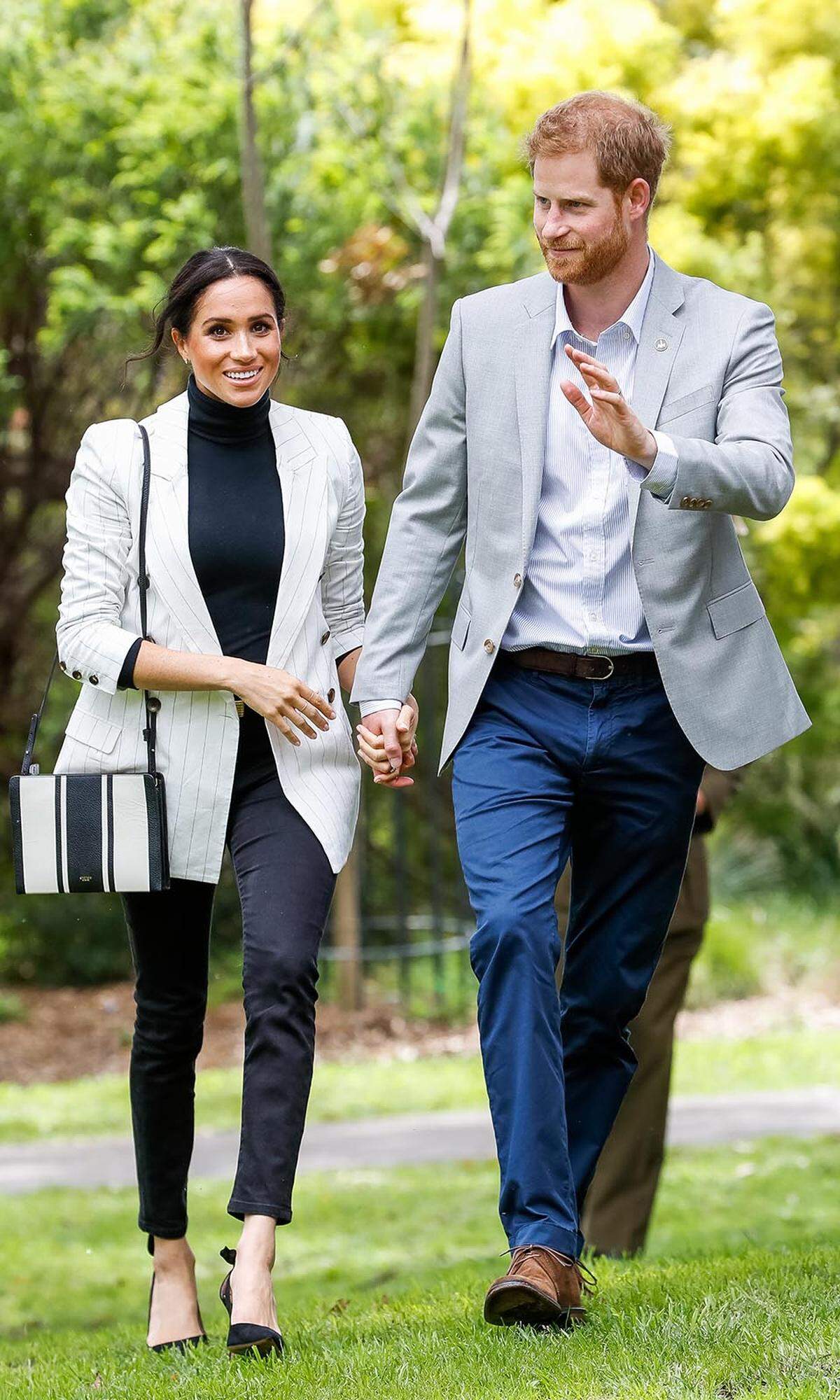 Ist Meghan die neue Fashion-Recycling-Queen? Am siebten Tag ihrer Australienreise zeigte sich die 37-Jährige in einer schlichten, aber gelungenen Kombination aus schwarzem Rollkragenpullover, Nadelstreif-Blazer (von L’Agence) und Skinny-Jeans (von Outland Denim). Dazu wählte sie eine schwarz-weiß gestreifte Umhängetasche der Marke Oroton, die uns sehr bekannt vorkommt: Schon im April hatte sich Meghan für das auffällige, aber nicht Dresscode taugliche, Accessoire entschieden. Auch bei ihrer Schuhwahl setzte sie auf etwas Altbewährtes: Die geliebten Aquazzura Pumps mit Schleifchen.