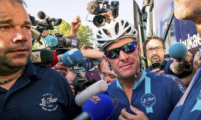 Cyclist Lance Armstrong of the US speaks to journalists before taking part in Geoff Thomas's 'One Day Ahead' charity event during a stage of the 102nd Tour de France cycling race from Muret to Rodez