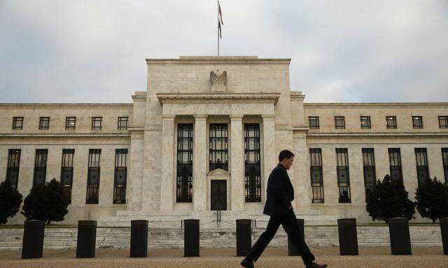 A man walks past the Federal Reserve in Washington