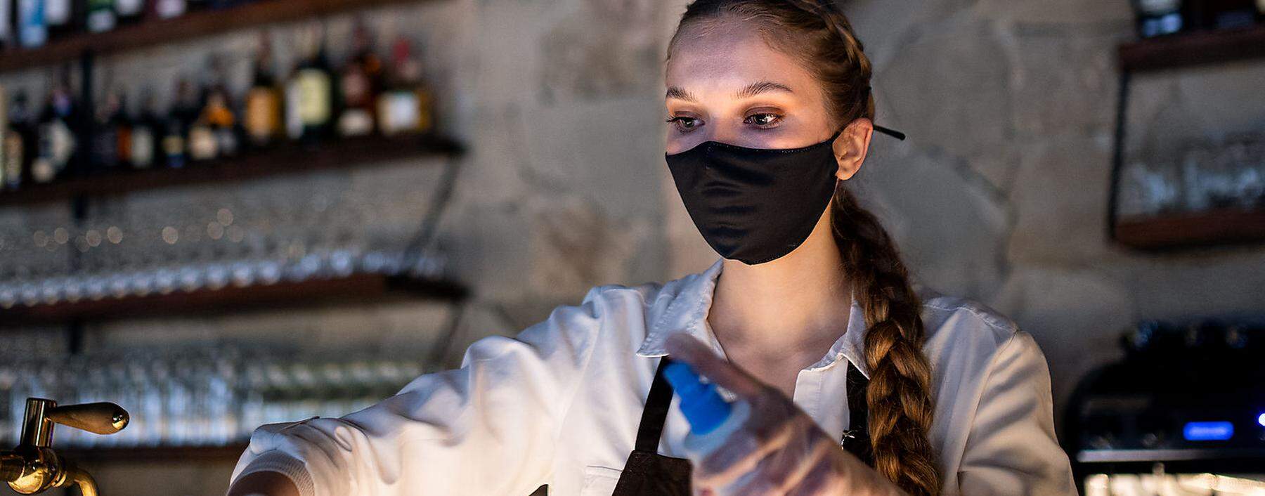 Waitress disinfecting surfaces in cafe, coronavirus and new normal concept.