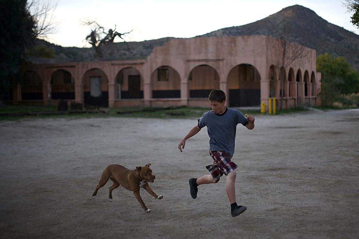 Nahe der mexikanischen Grenze spielt ein Bursch mit seinem Hund.